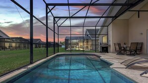 A swimming pool with a view of a house and a sunset. - Disney & Universal Escape 4 Bedroom Private Pool Orlando Theme Parks (Kissimmee)