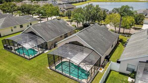 A residential area with houses, a swimming pool, and a lake. - Disney & Universal Escape 4 Bedroom Private Pool Orlando Theme Parks (Kissimmee)