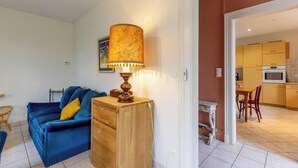 En stue med sofa, træskab og bordlampe.