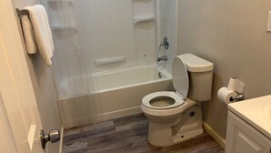 A bathroom with a bathtub, toilet, and a shower curtain. - Tremendous 3-bedroom house with AC in friendly Cleveland. 275 (Cleveland)
