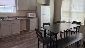 A kitchen with a microwave, refrigerator, and dining table with chairs. - Tremendous 3-bedroom house with AC in friendly Cleveland. 275 (Cleveland)