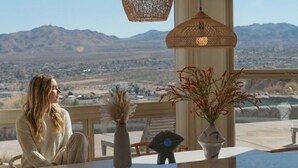 A person seated at a table with a view of mountains and a cityscape. - Ridge House with Pool, Hot Tub, Stars; near Joshua Tree & Pioneertown (Yucca Valley)