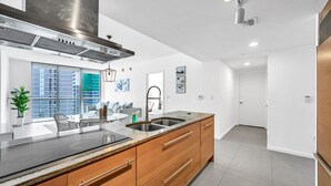 Una cocina moderna con una isla grande, electrodomésticos de acero inoxidable y vistas a la ciudad.