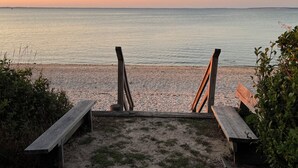 Una spiaggia con panchine di legno e una vista libera sul mare.
