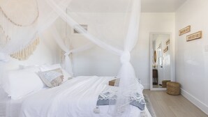 Un dormitorio con cama con dosel, dosel decorativo y un espejo con adornos.