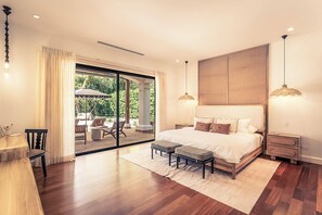 A bedroom with a large bed, a desk, and a view of a patio with outdoor furniture. - Luxury 5BR Villa - Hacienda Pinilla - Pool, Beach Club, Breakfast, House Keeping (Tamarindo)