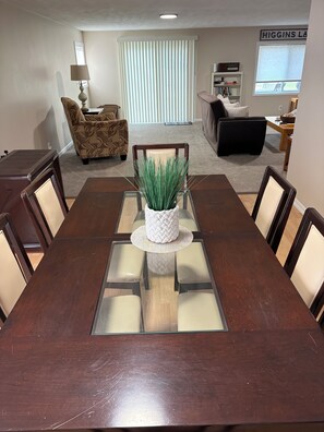 Un comedor con una mesa de madera, sillas y una planta en el centro.