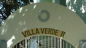 A gated entrance with a sign reading 'Villa Verde II' and multiple pet-related signs. - Cozy 2-bedroom apartment in charming Tamarindo with AC (Tamarindo)