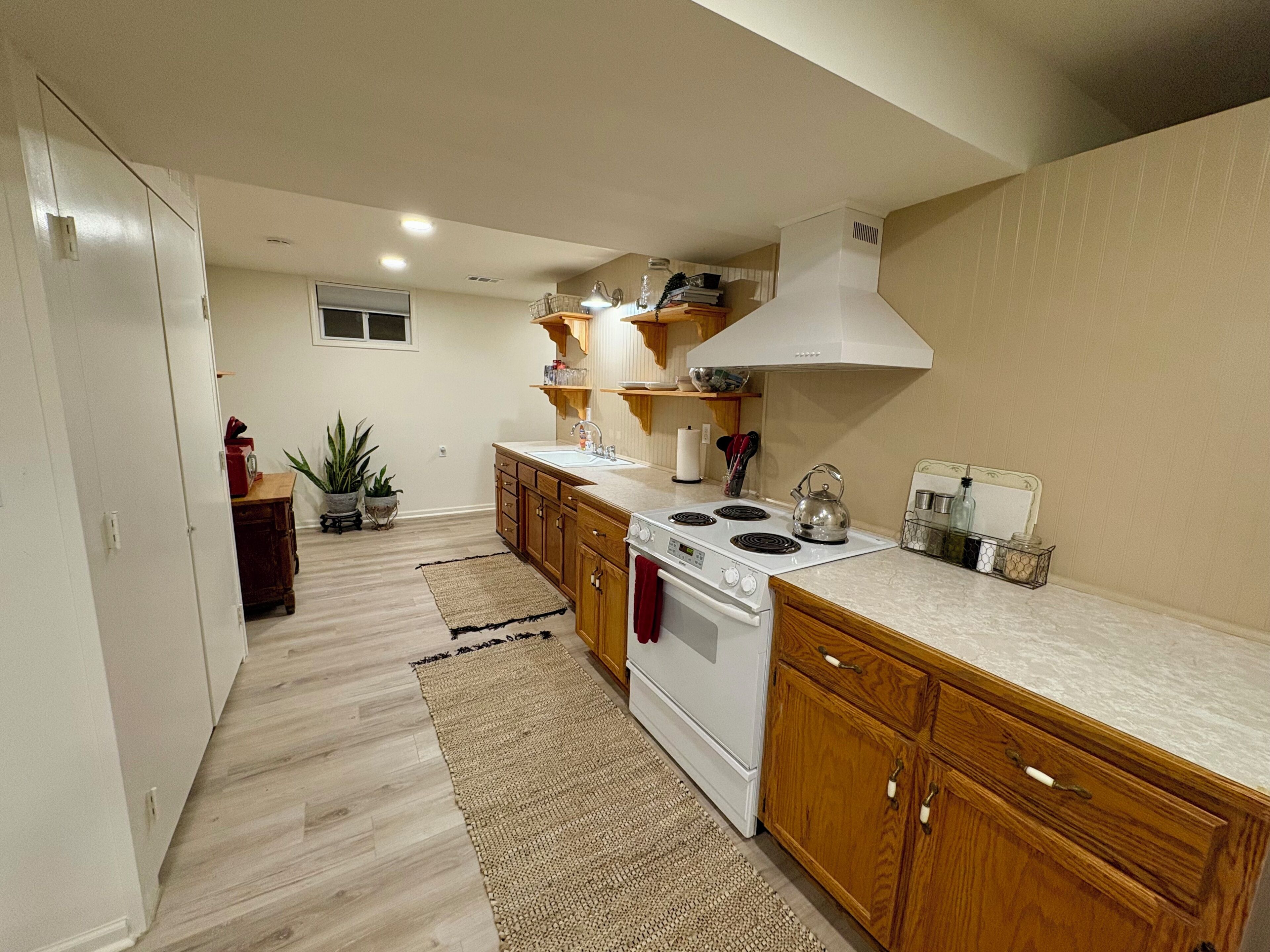 A kitchen with wooden cabinets, a white stove, and a countertop.