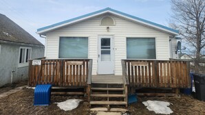 A single-story house with a front porch, a mailbox, and a satellite dish.