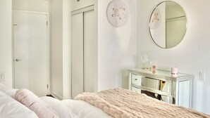 A bedroom with a bed, a dresser, a mirror, and a door. - Upscale Toronto Condo | Monthly Stay (Toronto)