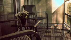A balcony with a table, chairs, and a potted plant. - Upscale Toronto Condo | Monthly Stay (Toronto)