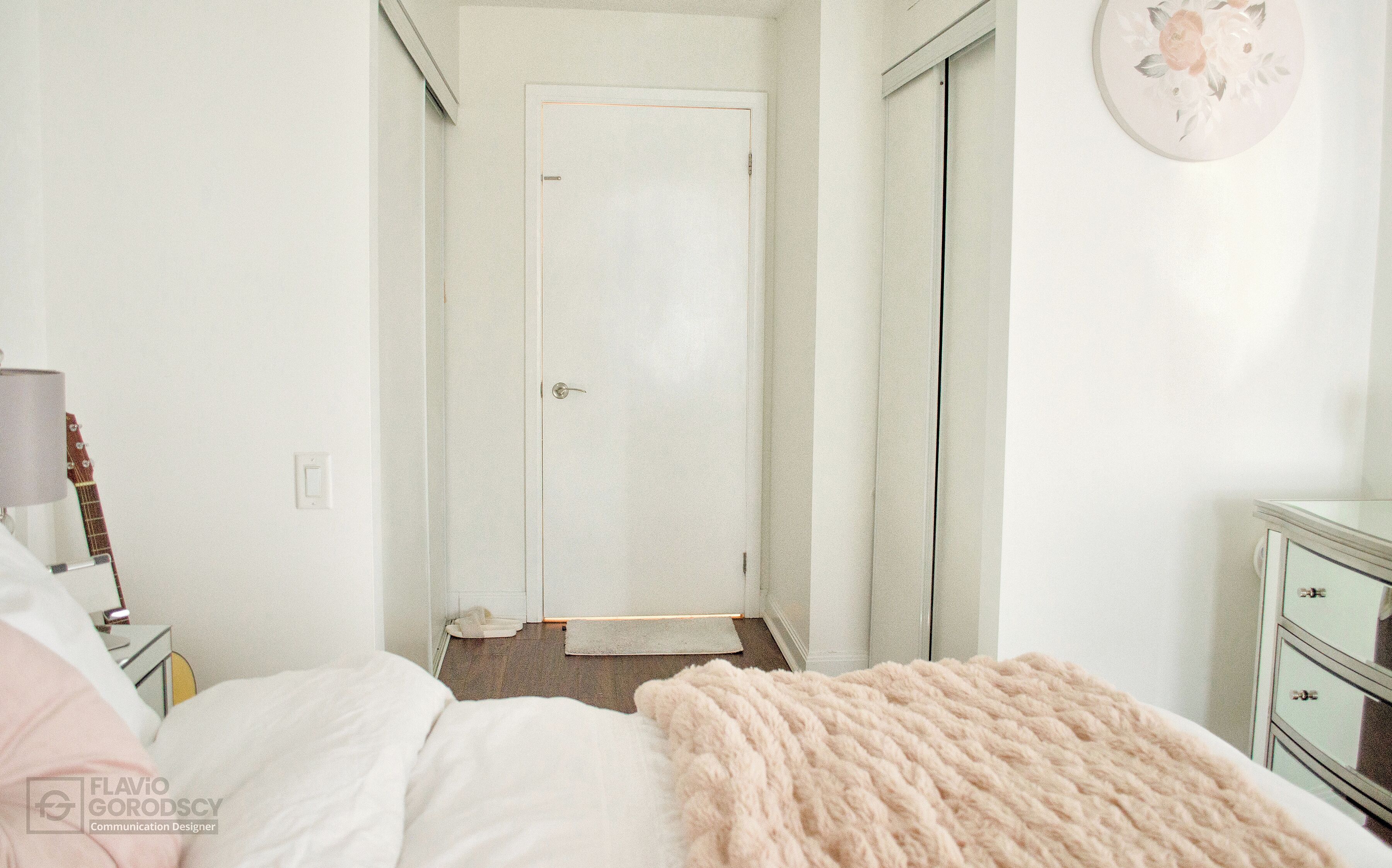 Une chambre à coucher avec un lit, une guitare, une commode et une porte.
