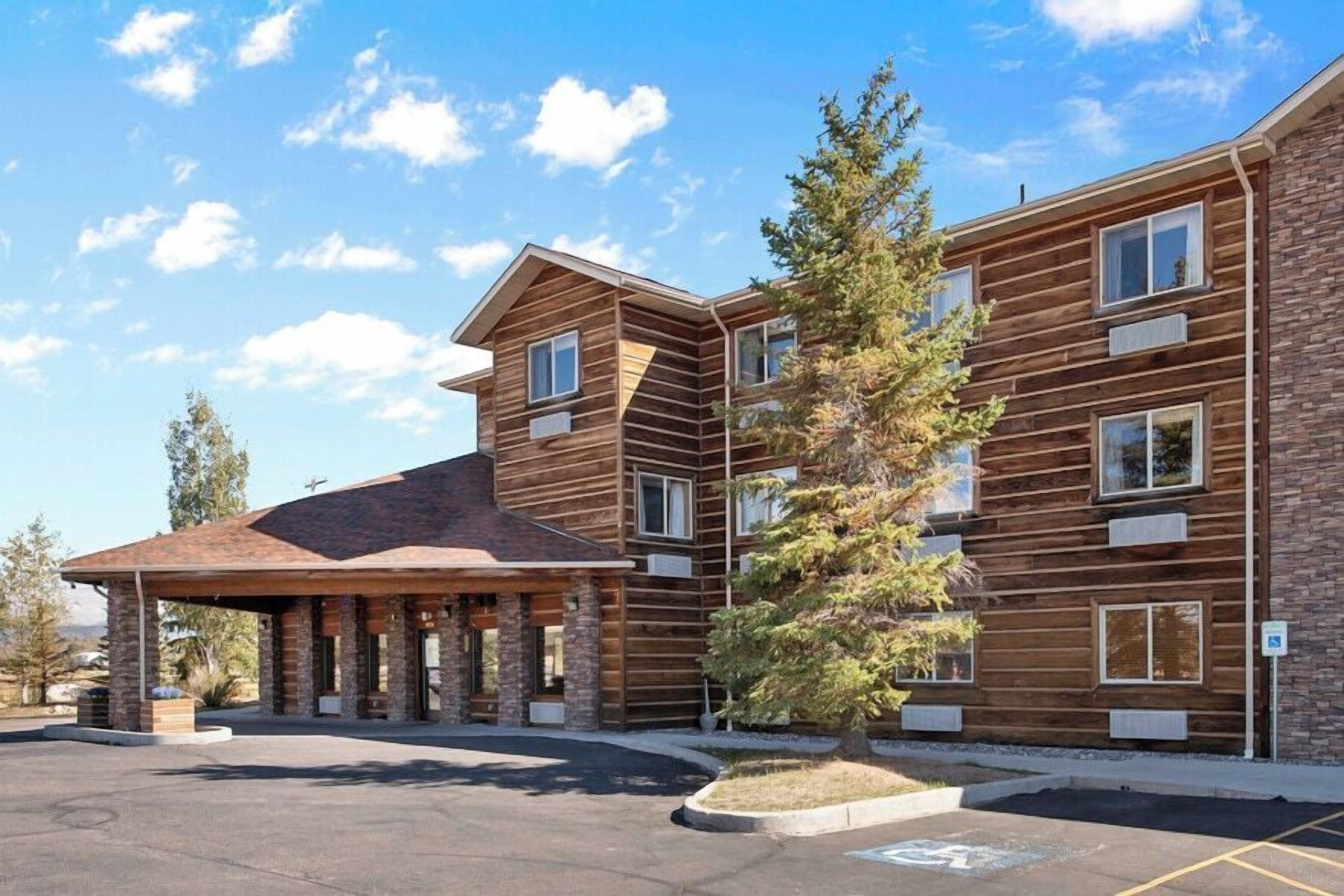 A multi-story building with a covered entrance and a parking lot.