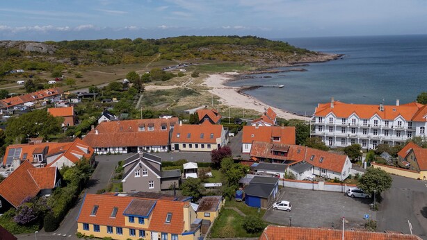 Una zona residencial costera con casas, una playa y vista al mar.
