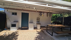 A covered outdoor area with a washing machine, a dryer, a table, and two fans. - Complete house with private pool and tranquility in Guanacaste, Costa Rica. (Huacas)