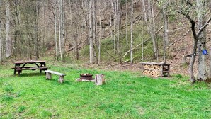 A picnic area with a table and benches, surrounded by a forest. - Tempest Ranch Camp is perfect for nature lovers. Close to Watkins Glen. (Beaver Dams)