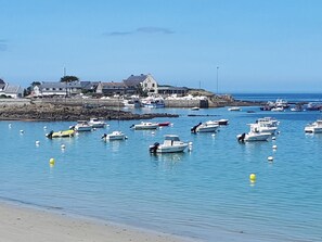 A coastal scene with boats docked near a sandy beach and houses in the background. - Ty Breizh - TREDREZ LOCQUEMEAU (TREDREZ LOCQUEMEAU)
