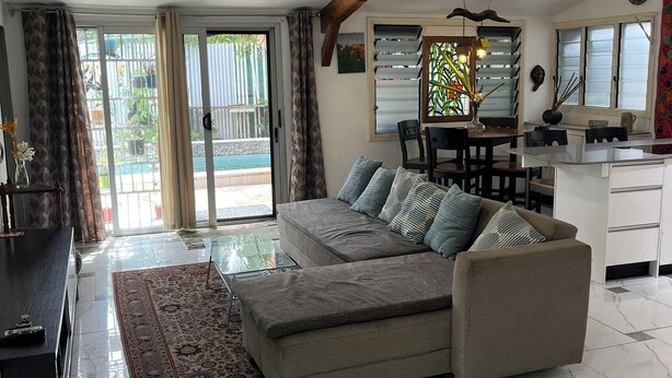 Amplia sala de estar con sofá, mesa de comedor y área de cocina.