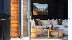Ein modernes Wohnzimmer mit einer Couch, einem Couchtisch und einem an der Wand befestigten Fernseher.