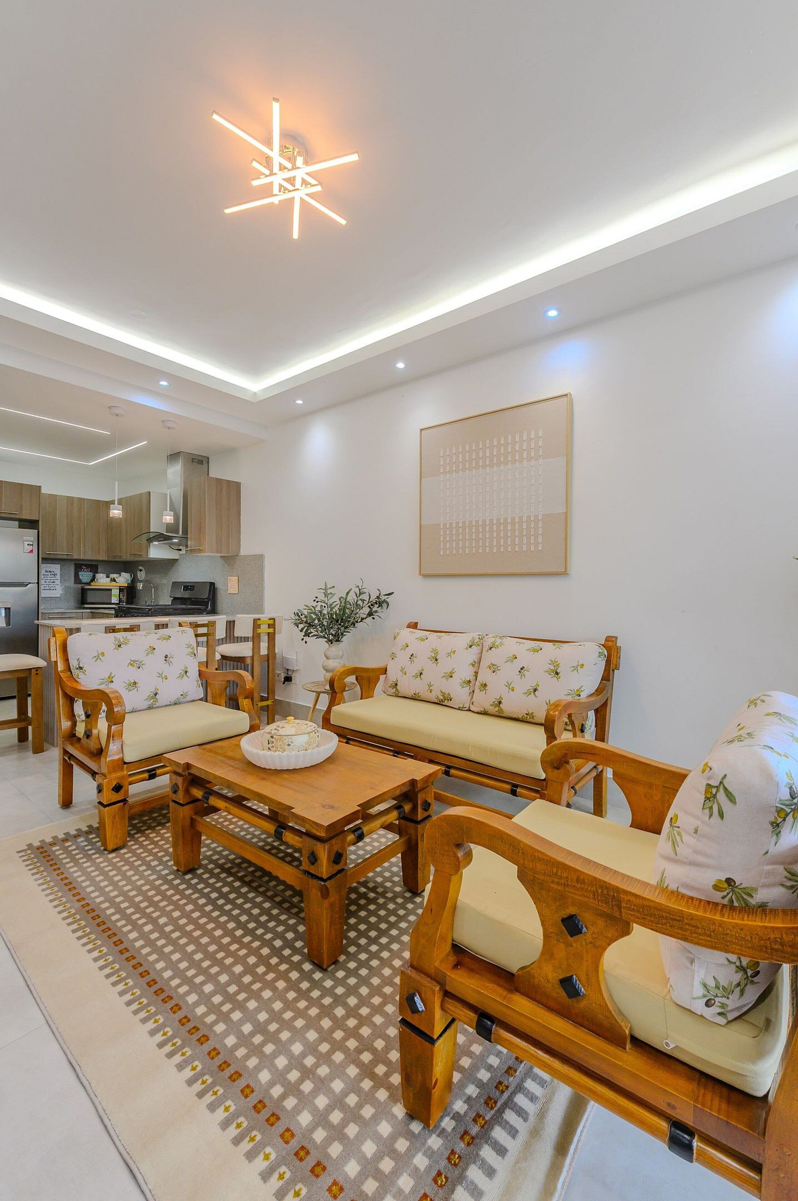 A modern living room with a sofa set, wooden coffee table, and a ceiling light fixture.