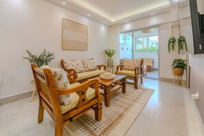 A living room with a sofa, chairs, a coffee table, and a potted plant. - Oasis de Comfort a Pasos del Mar (Boca Chica)