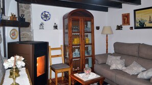 A cozy living room with a fireplace, wooden furniture, and decorative items.