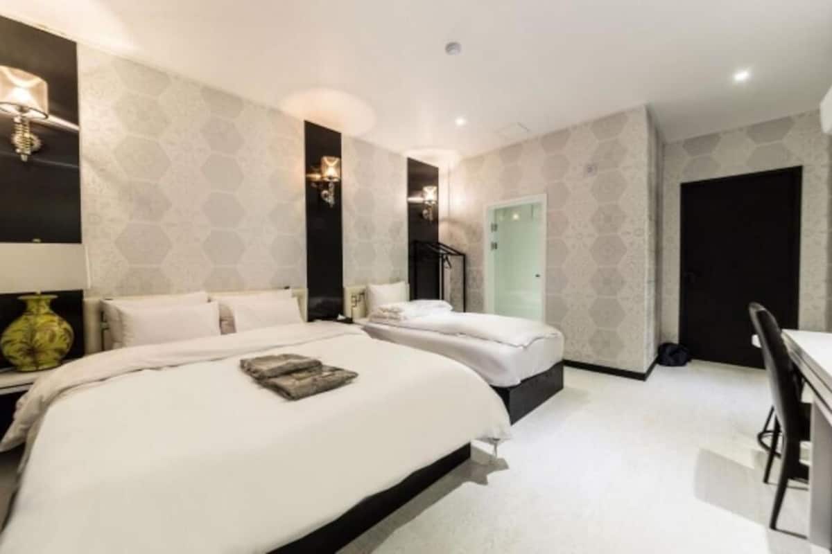 Una habitación de hotel con dos camas, un escritorio y una silla.