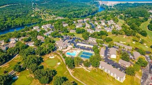 Vista aérea de una zona residencial con casas, piscina, canchas de tenis y campo de golf.