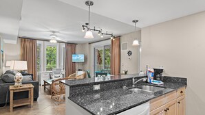 Eine moderne Küche mit Granit Arbeitsplatte, integriertem Geschirrspüler und Kaffeemaschine.
