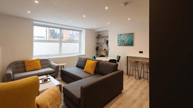A modern living room with two sofas, a coffee table, and a dining area with a table and chairs. - Central Leeds 1-bed Apartment Near Train Station (Leeds)
