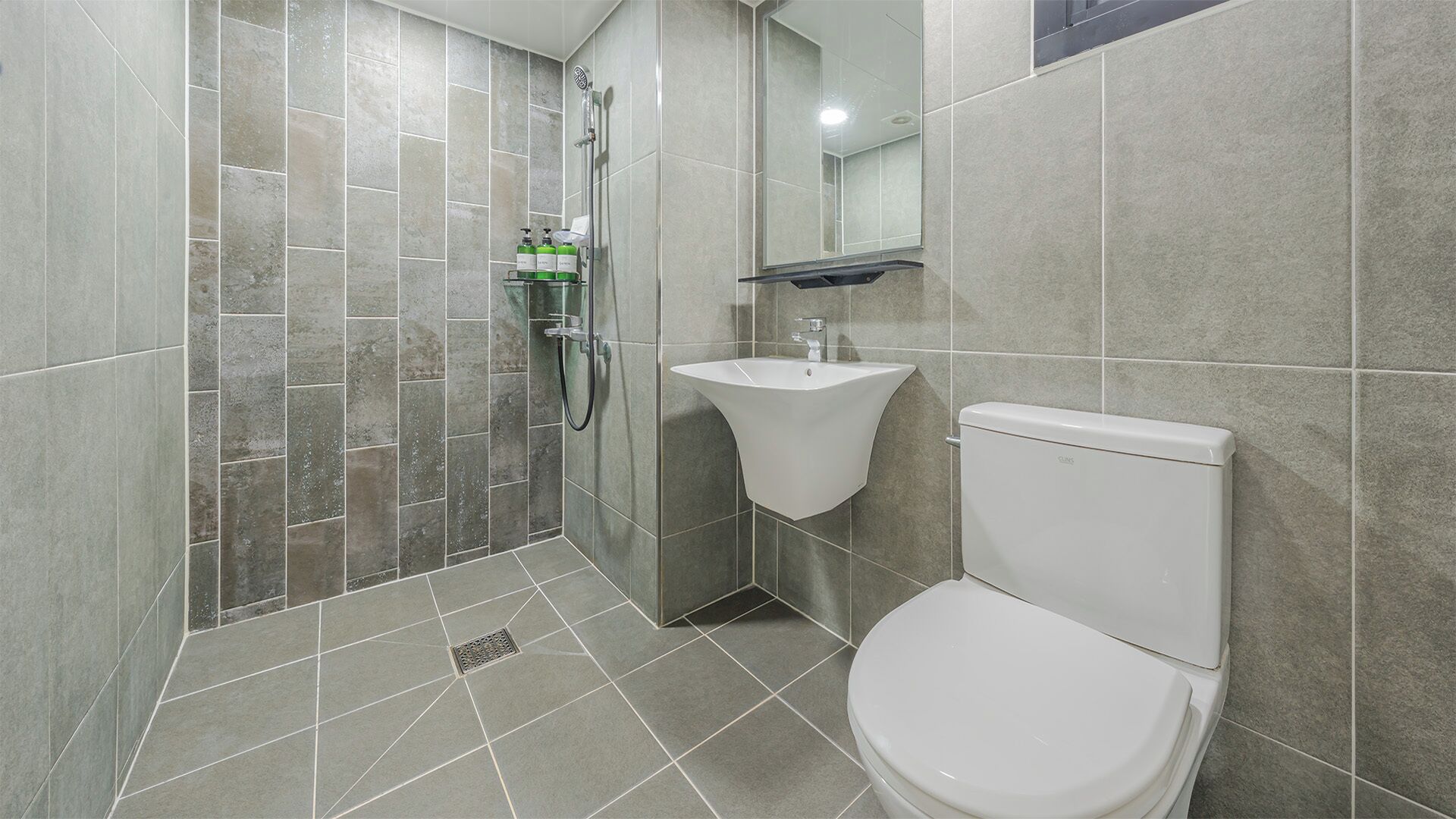 Ein modernes Badezimmer mit Dusche, Waschbecken und Toilette.