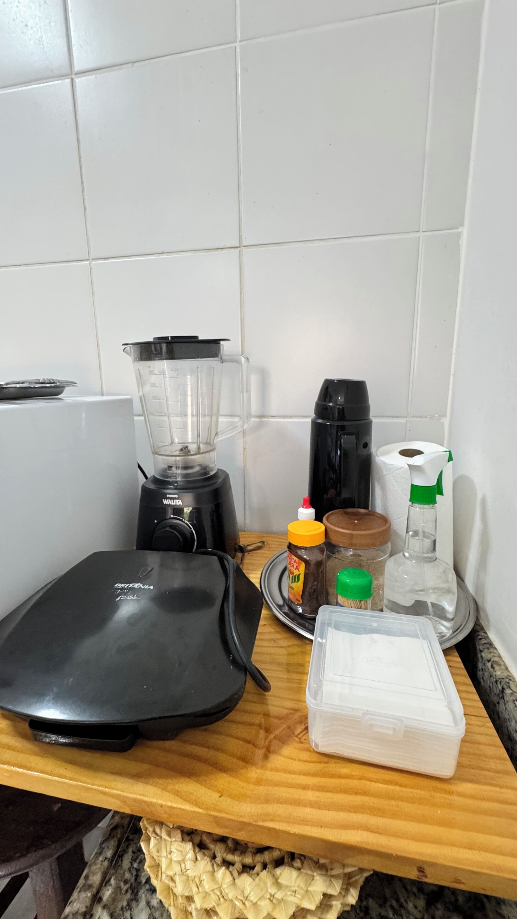 Un plan de travail de cuisine avec un mixeur, une machine à café et divers ustensiles de cuisine.