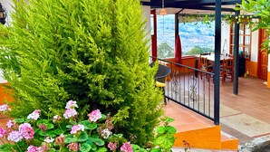 Un balcone con vista sulla città, un albero in vaso e un tavolo con sedie.