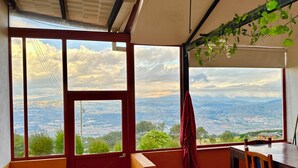 Una stanza con ampie finestre che offrono una vista panoramica sulla città e sulle montagne.