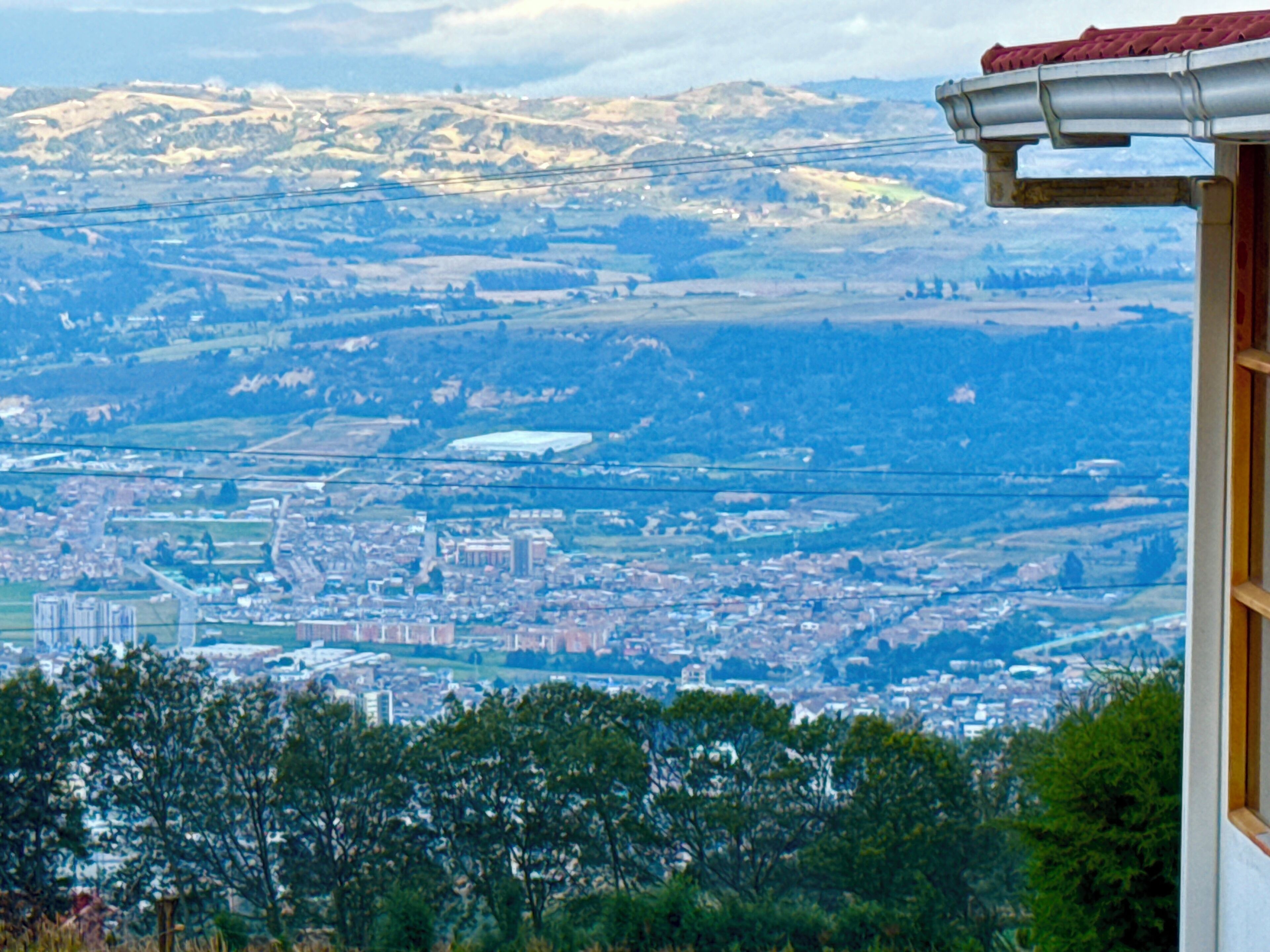 Ein weiter Panoramablick auf eine Stadt, einschließlich Gebäude, Straßen und ferner Berge.