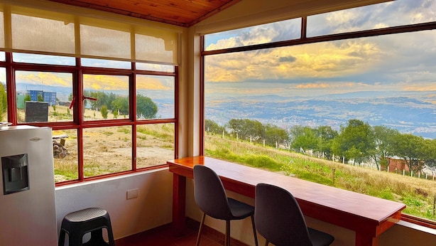 Una cucina con vista sul paesaggio, soffitto in legno e finestra che si affaccia sulla campagna.