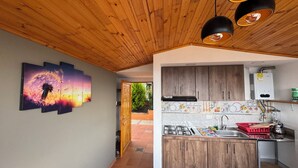 Cucina con pensili in legno, piano cottura a gas e lavello.