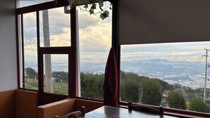 Una stanza con un'ampia finestra che si affaccia su una vista della città e delle montagne.