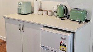 Une cuisine compacte équipée d’un four à micro-ondes, d’un grille-pain et d’un réfrigérateur.