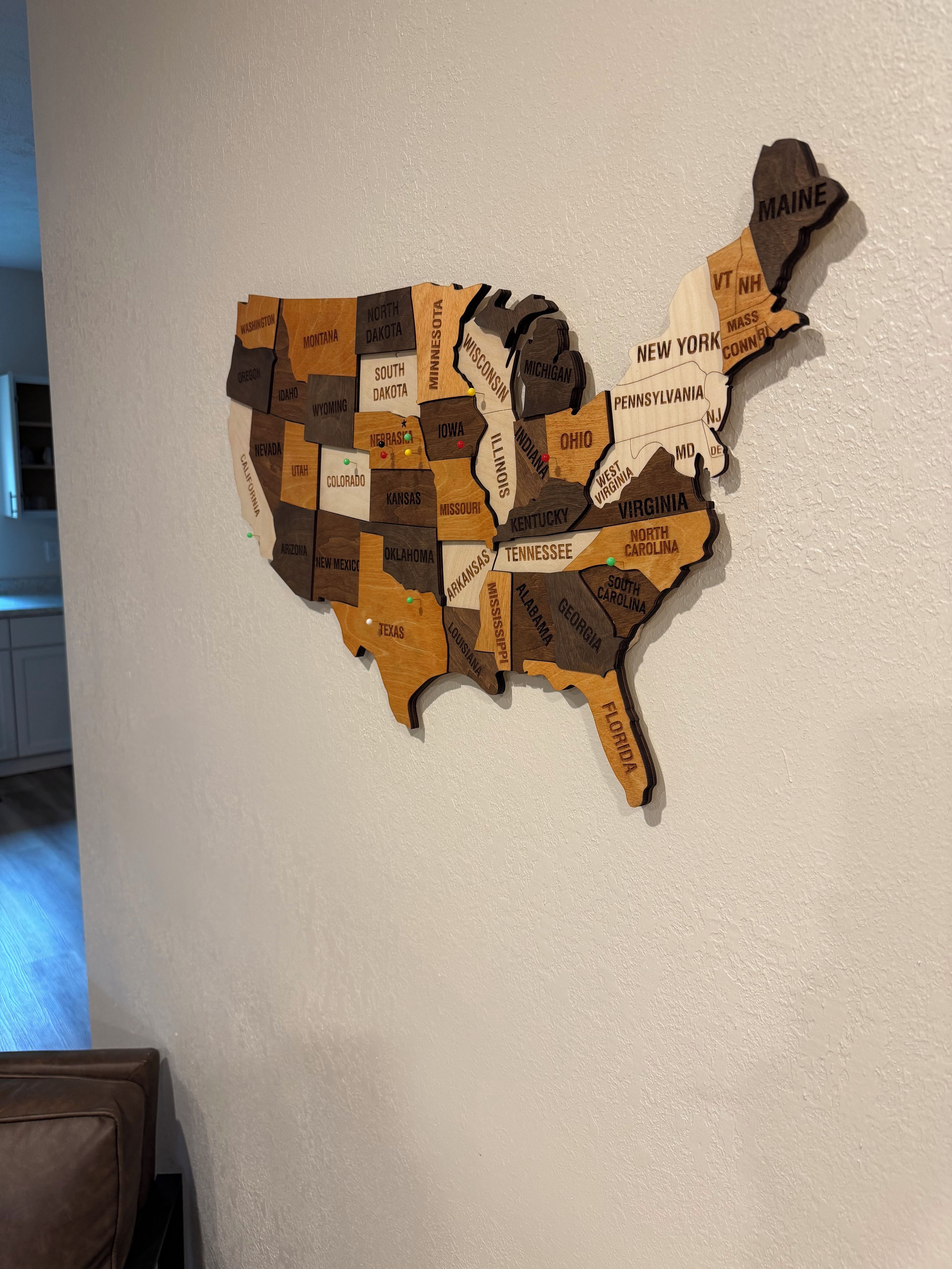 En väggmonterad träkarta över USA med namnen på delstaterna och deras gränser.