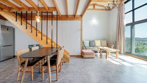 A modern interior with a dining area, staircase, sofa, and large windows. - Yangyang Little Forest Pension (Yangyang)