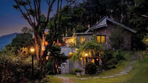 A house with a brick exterior, a wooden deck, and a stone pathway leading to the entrance.