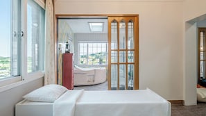Una habitación de hotel con cama, ventana, vista al exterior y baño con bañera.