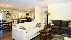 A living room with a white sofa, a dark sofa, a wooden coffee table, and a ceiling fan. - Rehoboth Beach House Pet Friendly Fenced Yard Next to Trail (Rehoboth Beach)