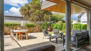 An outdoor patio area with a table and chairs, a sofa, and a coffee table. - Roberts Street Retreat - Taupo CBD (Taupo)