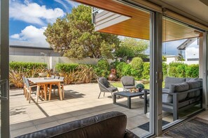 An outdoor patio area with a table and chairs, a sofa, and a coffee table. - Roberts Street Retreat - Taupo CBD (Taupo)