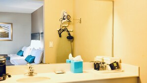 Een hotelbadkamer met een wastafel, spiegel en toiletartikelen.