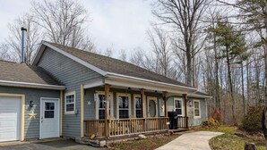 A single-story house with a covered porch, a garage, and a chimney. - Storybook Craftsman Cottage - Annapolis Valley (Aylesford)