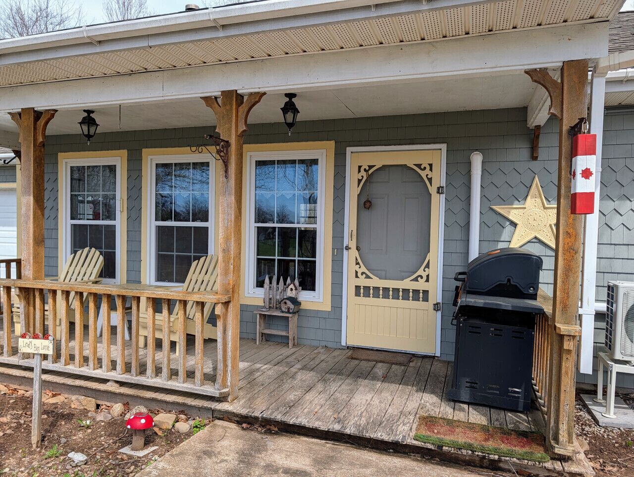 A house with a porch, three windows, a door with a star emblem, and a grill.
